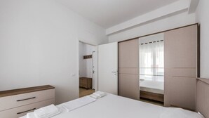 Una camera da letto con un letto, un armadio, un comodino e uno specchio.