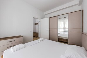 A bedroom with a bed, a wardrobe, a bedside table, and a mirror. - Central Quiet Tirana Flat 1BR Apartment (Tirana)