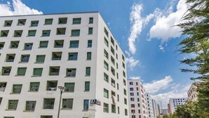 Un edificio moderno a più piani con facciata lineare, numerose finestre e un cartello che indica che si tratta di un hotel.