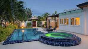 A swimming pool with a hot tub, lounge chairs, and a covered patio area. - Orchid Paradise Homes OPV307 (Tambon Hin Lek Fai)
