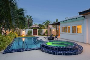 A swimming pool with a hot tub, lounge chairs, and a covered patio area. - Orchid Paradise Homes OPV307 (Tambon Hin Lek Fai)