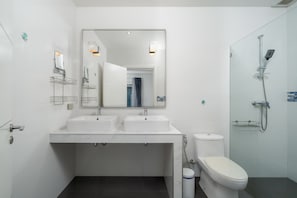 A modern bathroom with two sinks, a toilet, a shower, and a large mirror. - Orchid Paradise Homes OPV307 (Tambon Hin Lek Fai)