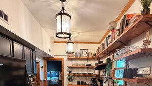 A kitchen with wooden cabinets, a black refrigerator, a wooden countertop, and a hanging light fixture. - The Schoolhouse Cabin - 2BR, 1.5BA with Hot Tub and Game Room (Hudson)