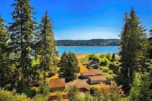 A residential area with houses, a clear blue sky, and a lake in the background.