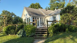 Ein Haus mit Veranda, Holzterrasse und Garten.