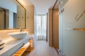 Une salle de bain moderne avec un grand lavabo, un miroir et une douche.