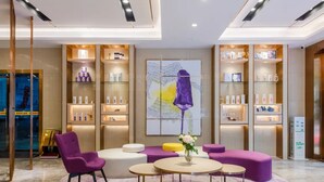 A modern lobby with a central seating area, shelves with products, and a large abstract painting. - Lavande International Hotel Guangzhou Taigucang Shayuan Metro Station Branch - Free Shuttle Bus to Canton Fair Complex During Canton Fair Period (Guangzhou)