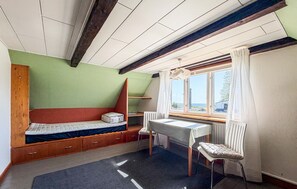 Una habitación pequeña y acogedora con una cama, un escritorio y una ventana.