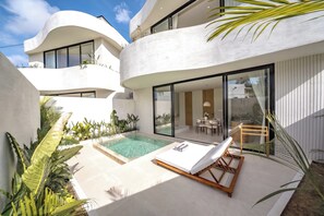 Un edificio moderno con piscina, sillas de descanso y zona de comedor.