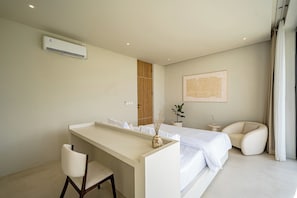 Un dormitorio moderno con cama, escritorio, silla, planta en maceta y equipo de aire acondicionado.