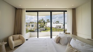 Habitación de hotel moderna con una cama grande, un sofá y vistas del entorno.