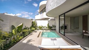 Un área de piscina moderna con una vista despejada del cielo, una piscina y sillas de descanso.