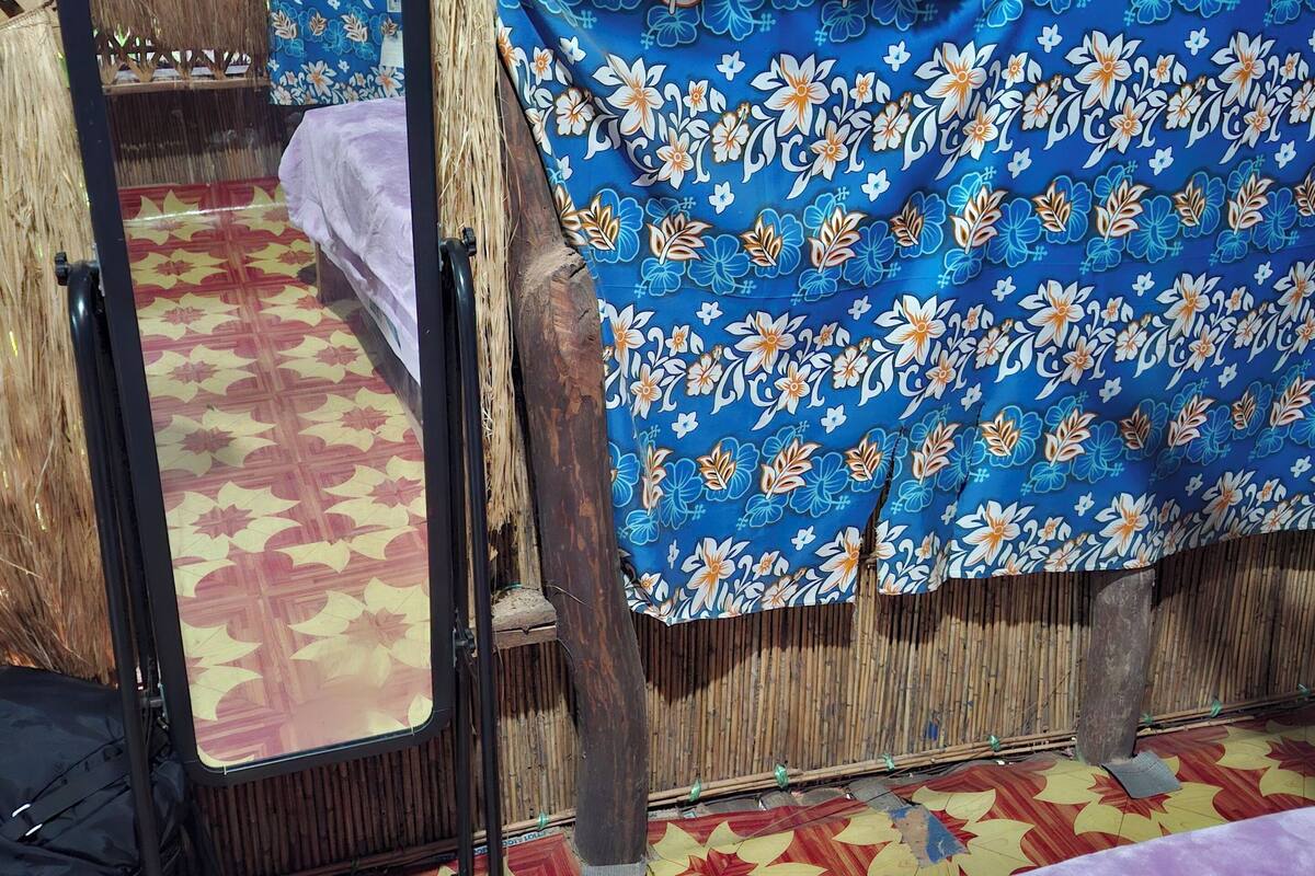 A room with a bed, a mirror, and a patterned floor.