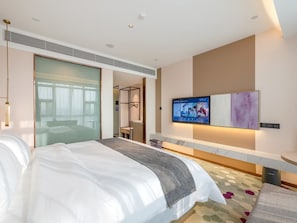A modern hotel room with a large bed, a television, and a glass partition wall. - Lavande International Baiyun Airport (Guangzhou)