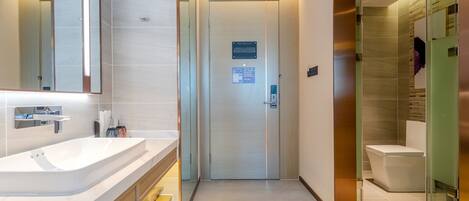 A modern bathroom with a large sink, mirror, and glass shower enclosure.