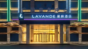 L’entrée d’un hôtel, avec une enseigne bien visible portant l’inscription « LAVANDE » et des caractères chinois.