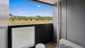 Un balcone con vista su un edificio e un paesaggio.