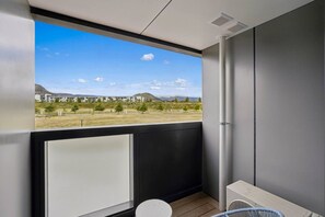 Un balcon donnant sur un bâtiment et un paysage.