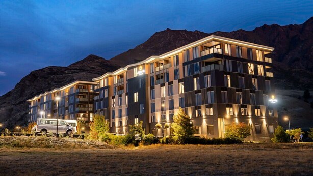 Un hotel moderno a più piani, situato in una zona montuosa.