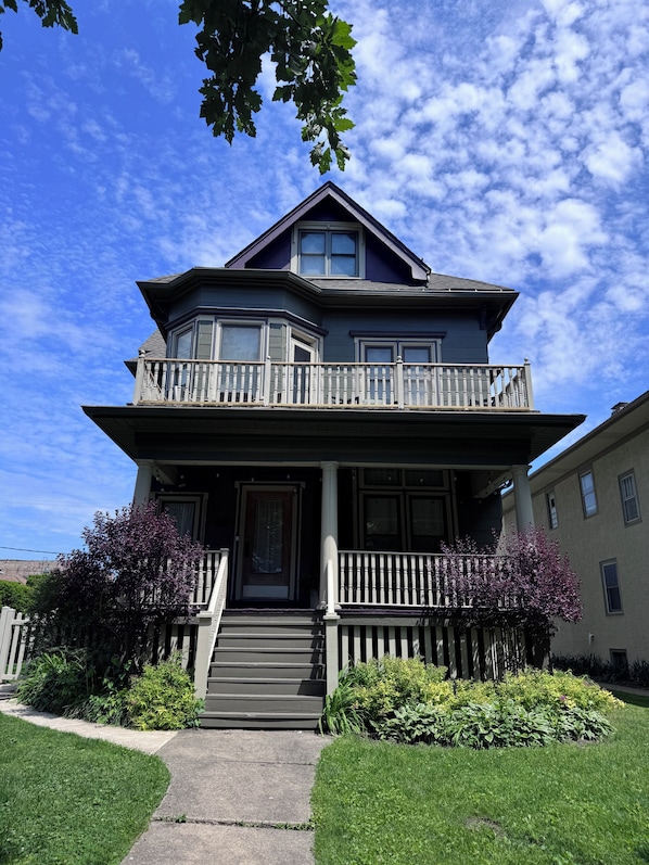 A two-story house with a balcony, a front porch, and a driveway.