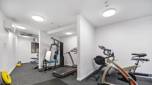 Ein Fitnessraum mit Trainingsgeräten, Laufband und Ergometer.