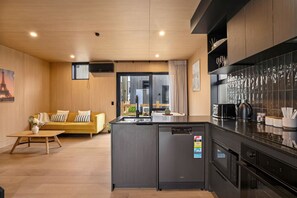 Eine moderne Küche mit integriertem Kühlschrank, ein Essbereich mit einer Couch und Blick auf die Stadt.