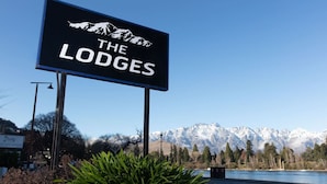 Une enseigne indiquant « The Lodges », avec une montagne en arrière-plan.