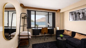 Une pièce comprenant un bureau, une chaise, un canapé et un grand miroir.