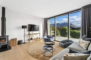 Uma sala de estar moderna com lareira, um sofá, uma mesa de centro e uma televisão.