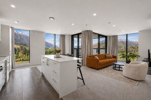 Un salon moderne avec un canapé, une table basse et une vue sur les montagnes.
