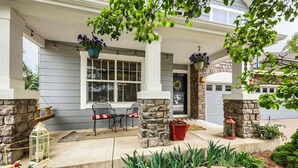 A house with a porch, stone pillars, a window, and outdoor seating. - Comfy 4-Bedroom House in Castle Rock with Priv. Fenced-in Backyard/Dog Friendly. (Castle Rock)