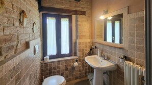A bathroom with a toilet, sink, and window with curtains. - Lovely home in Sarnano with swimming pool (Sarnano)