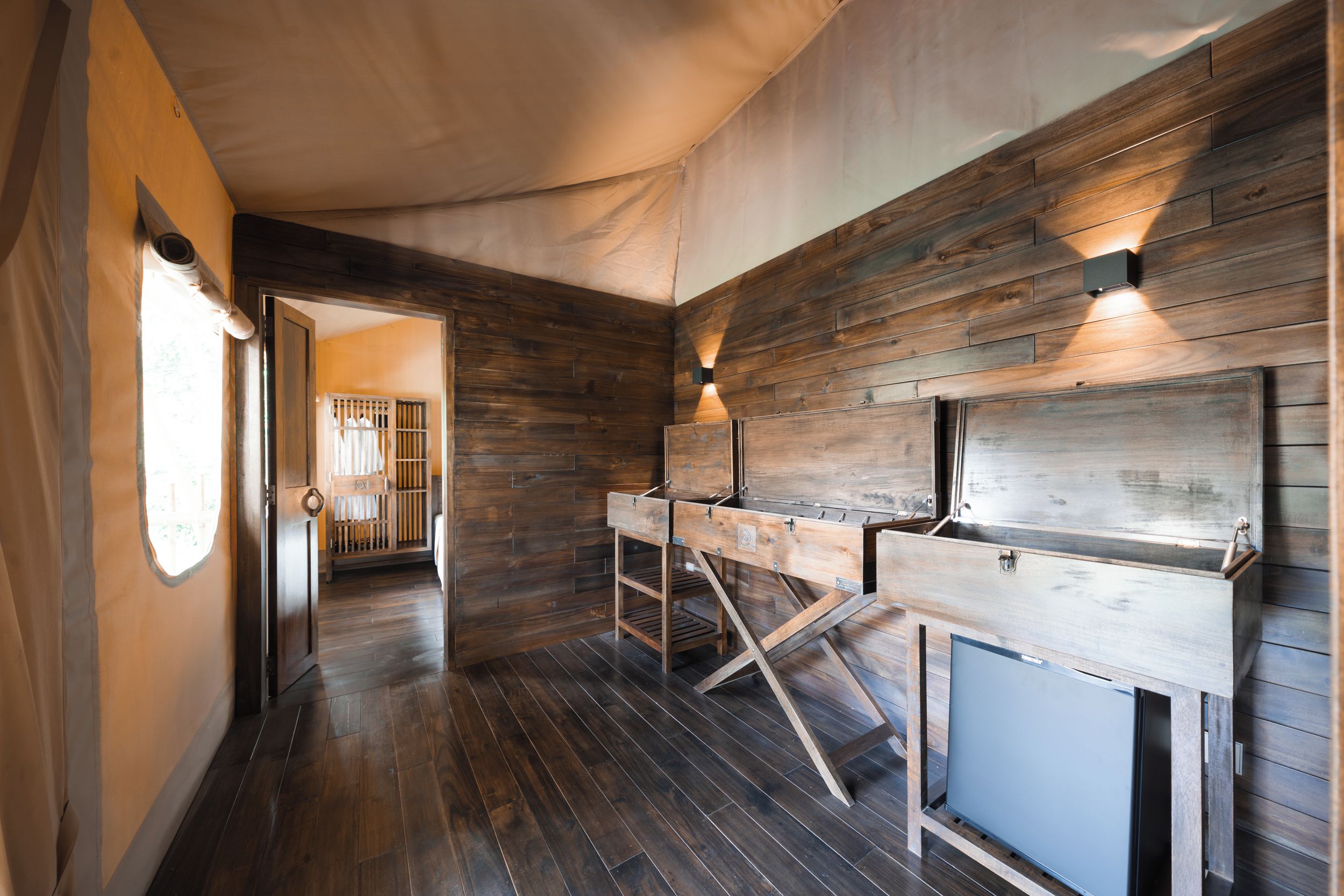 Una habitación con paneles de madera en las paredes, un techo tipo tienda y suelo de madera.