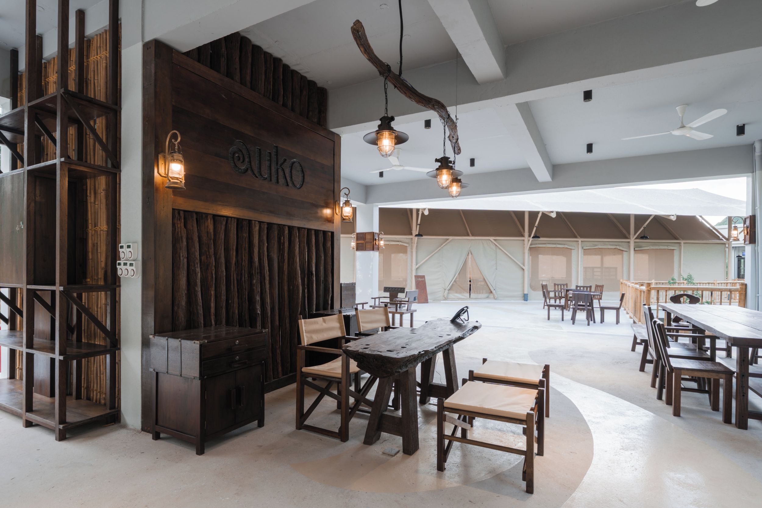 Un interior amplio con muebles de madera, techo alto y vigas a la vista.