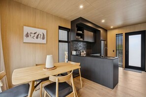 Een moderne keuken met een centraal eiland, een houten eettafel en stoelen.