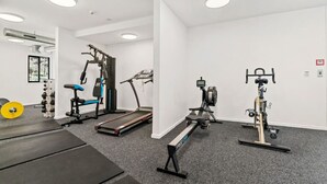 A gym with cardio machines, free weights, and a treadmill.
