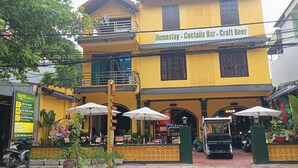 A yellow building with a sign for 'Homestay - Cocktails Bar - Craft Beer.' - Favos Bich Dong (Ninh Binh)
