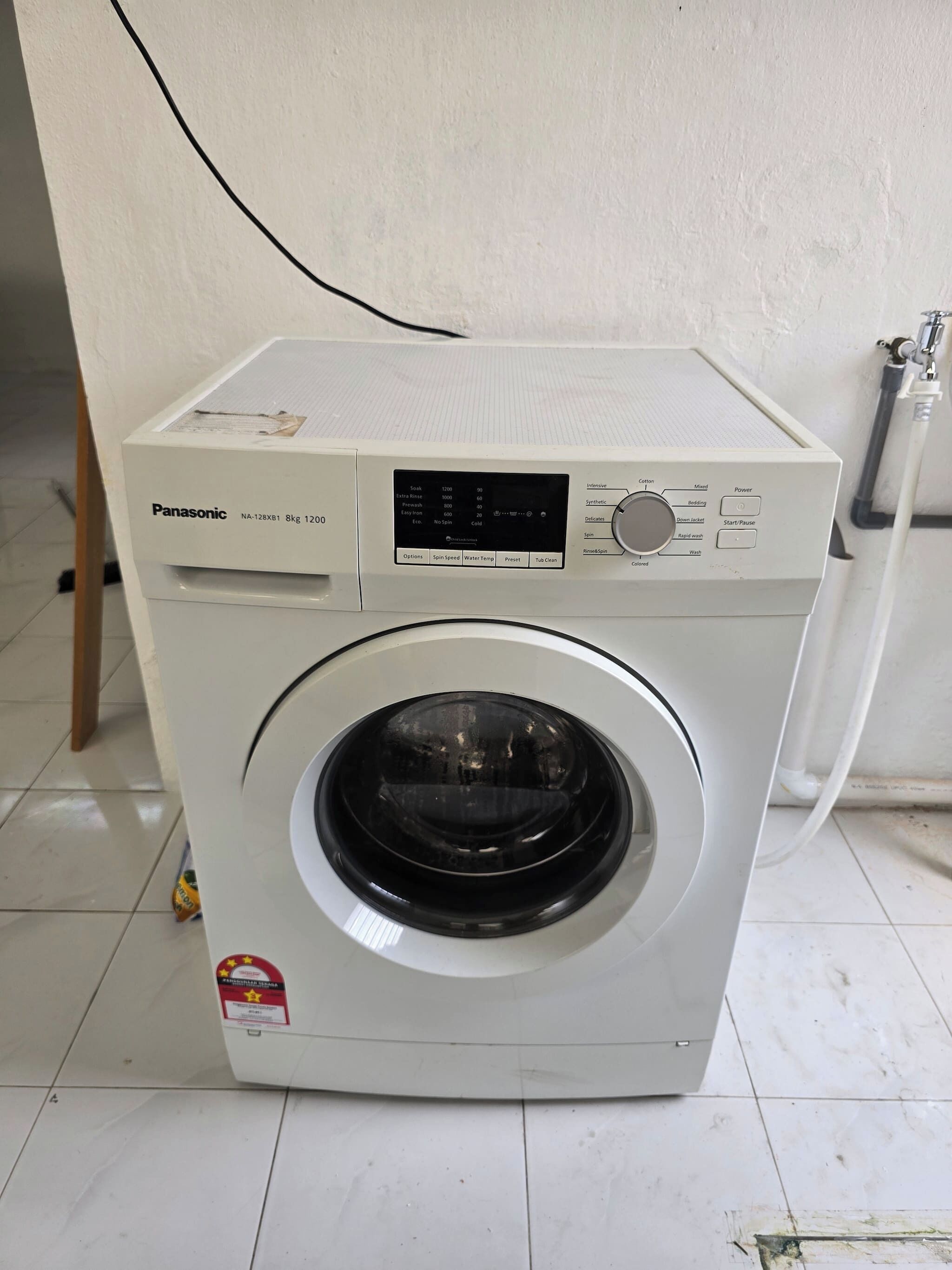 A Panasonic washer with a digital display, control panel, and a front-loading door.