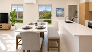 Una cocina moderna con comedor, ventanas amplias y un televisor de pantalla plana.