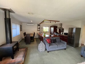 A compact living space with a kitchenette, a sofa, a dining area, and a fireplace. - The Iron Gate - Best Value and Pet Friendly! (Cromwell)