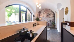 Een moderne keuken met een bar, een stenen muurschildering en uitzicht op de omgeving.