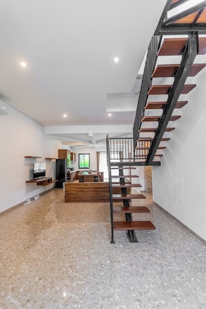 Een modern interieur met een trap, keuken en een eethoek.