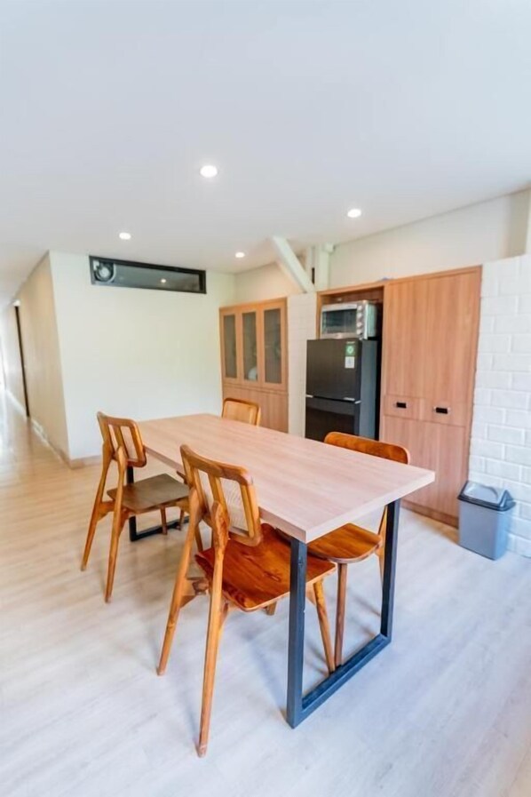 Una cocina moderna con gabinetes de madera, microondas integrado y un refrigerador.