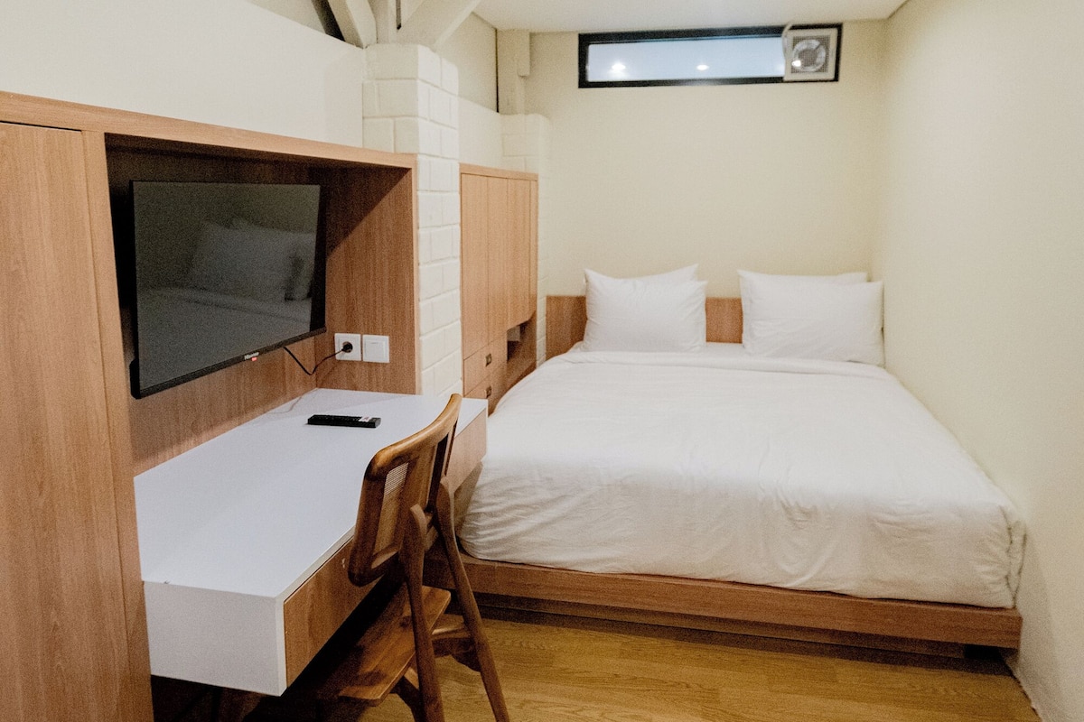 Une chambre à coucher avec un lit, un bureau et un téléviseur.