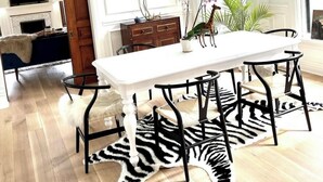 A dining area with a white table, black chairs, a zebra-patterned rug, and a plant on the table. - Beautiful, spacious 5-bedroom house in downtown Oak Park very close to Chicago (Oak Park)