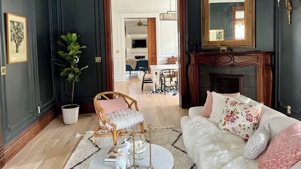 A room with a white sofa, a wooden chair, a chandelier, a fireplace, and a large mirror. - Beautiful, spacious 5-bedroom house in downtown Oak Park very close to Chicago (Oak Park)