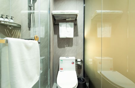 A modern bathroom with a glass shower enclosure, a toilet, and a sink with soap dispensers.. Aifeel Hotel Beijing Capital Airport T3