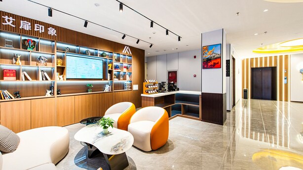 A modern hotel lobby with a reception desk, seating area, and a large digital display. - Aifeel Hotel Beijing Capital Airport T3  (Shunyi)