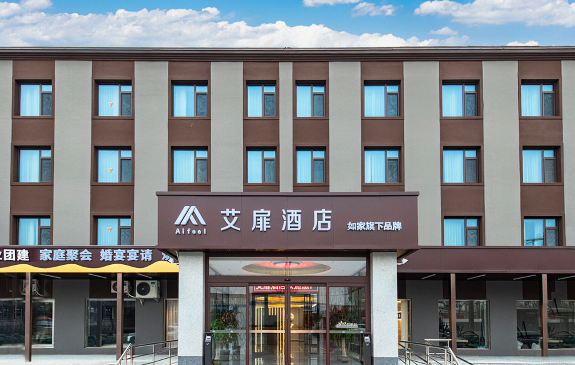 A hotel with a modern facade, multiple windows, and a prominent entrance with glass doors.
