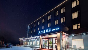 A hotel with a modern facade, large windows, and a well-lit entrance. - Aifeel Hotel Beijing Capital Airport T3  (Shunyi)